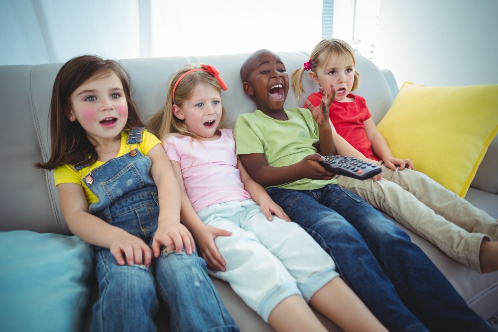 crianças no sofá assistindo filme de sessão da tarde anos 90
